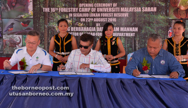 TERMETERAI: Sam Mannan bersama Law Hui Kong (kiri) dan Dr. Sharil menandatangani lanjutan Surat Hasrat (LoI).